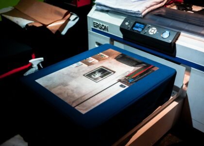 Close-up of a professional printer printing a custom artwork design on fabric in a studio setting.